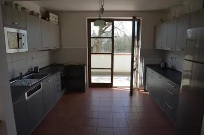 a kitchen with white cabinets and a door to a yard at Statek Krkavčí Hora in Nižbor