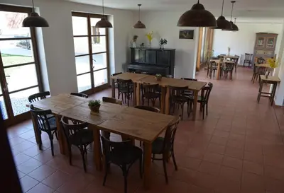 a dining room with wooden tables and chairs at Statek Krkavčí Hora in Nižbor