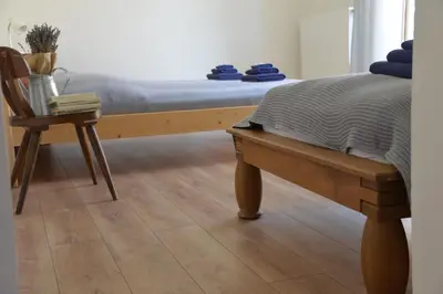 a bedroom with a bed and a wooden bench at Statek Krkavčí Hora in Nižbor