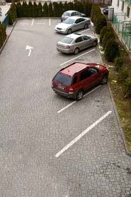 a red car parked in a parking lot at Hotel Atlas in Benešov