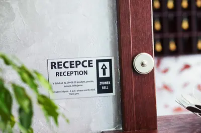 a sign on a door that reads respect reception at Hotel Atlas in Benešov