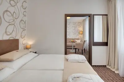a hotel room with two beds and a dining room at Hotel Atlas in Benešov