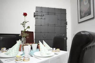 a table with plates and a vase with a flower on it at Pension Konopiste in Benešov