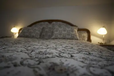 a bedroom with a bed with two lamps on it at Pension Konopiste in Benešov