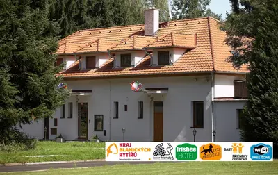 a white house with a sign in front of it at Pension Konopiste in Benešov