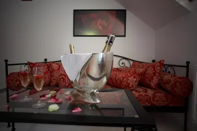 a living room with a table with two wine glasses at Pension Konopiste in Benešov