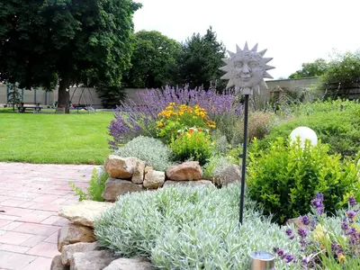 a garden with flowers and a sun sign in the middle at Hotel Dvůr in Krnsko