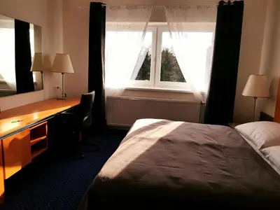 a bedroom with a bed and a desk and a window at Hotel Dvůr in Krnsko