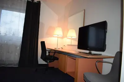 a room with a desk with a television and a chair at Hotel Dvůr in Krnsko