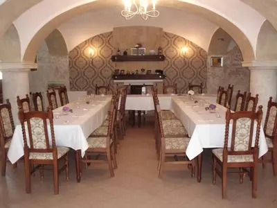 a large dining room with white tables and chairs at Hotel Dvůr in Krnsko