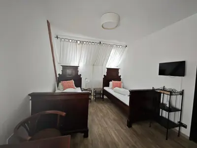 a living room with two beds and a tv at Penzion U Švarců in Zduchovice