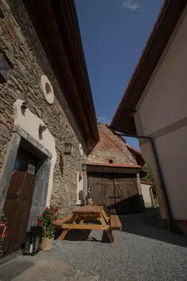 a wooden picnic table in front of a building at Penzion U Švarců in Zduchovice