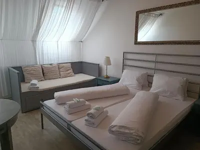 a bedroom with two beds with towels and a mirror at Penzion U Švarců in Zduchovice