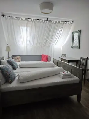 a bedroom with two large beds and a table at Penzion U Švarců in Zduchovice