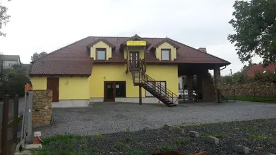a yellow house with a staircase in front of it at Penzion AMÁLKA Černín in Zdice