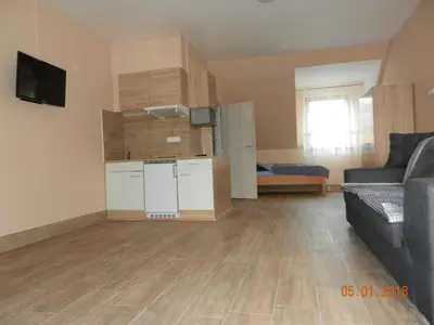 a living room with a couch and a kitchen at Penzion AMÁLKA Černín in Zdice