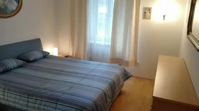 a bedroom with a bed with a blue comforter and a window at Zderaz in Prague