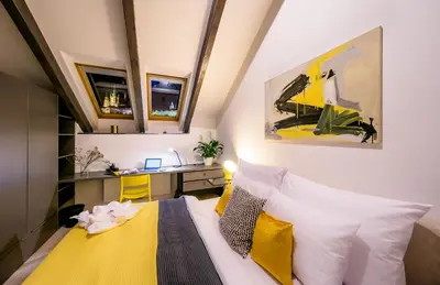 a small bedroom with a bed and a desk at President APT by Prague Castle, VIEWS in Prague