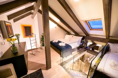 a small attic room with a bed and a window at President APT by Prague Castle, VIEWS in Prague