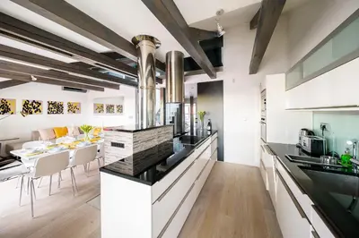 a kitchen with black countertops and a dining table at President APT by Prague Castle, VIEWS in Prague