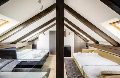 a attic bedroom with two beds and a window at President APT by Prague Castle, VIEWS in Prague