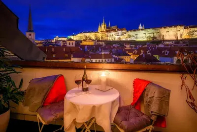 a table on a balcony with a view of a city at President APT by Prague Castle, VIEWS in Prague