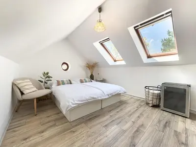 a white bedroom with a bed and a tv at Apartmán Vikárka - dům Karla Hynka Máchy - Litoměřice in Litoměřice