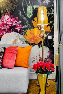 a living room with a couch and a lamp and flowers at Drama Queen in Old Town Prague in Prague