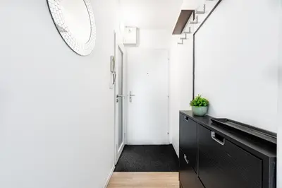 a hallway with a black cabinet and a white door at Family apartment Prague in Prague