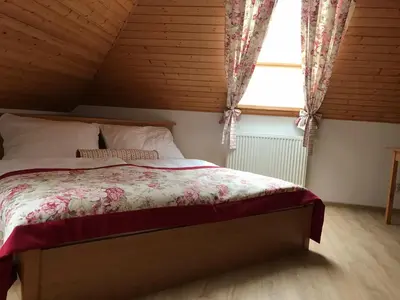 a bedroom with a bed in a attic with a window at Penzion Karlštejn in Karlštejn