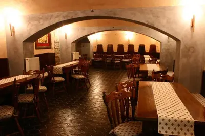 a restaurant with tables and chairs in a room at Zlaty Lev in Louny