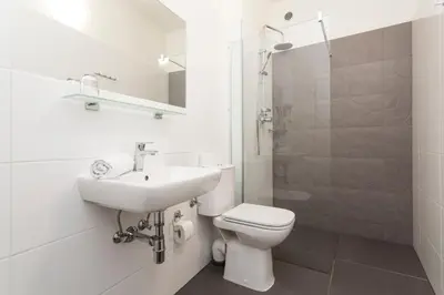 a bathroom with a toilet and a sink and a shower at Pension Akat in Prague