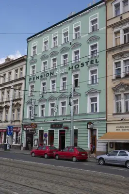 a green building with cars parked in front of it at Pension Akat in Prague