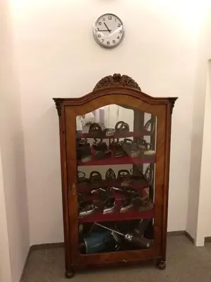 a clock on a wall above a cabinet filled with shoes at Pension Akat in Prague