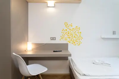a bedroom with a bed and a desk and a chair at Pension Akat in Prague