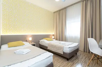 a hotel room with two beds and a window at Pension Akat in Prague