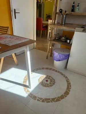 a kitchen with a table and a tile floor at ARTHARMONY Pension & Hostel in Prague