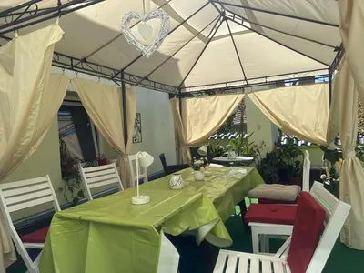 a table with a green tablecloth and chairs under a tent at ARTHARMONY Pension & Hostel in Prague