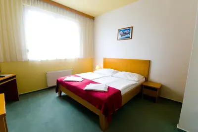 a bedroom with a bed with a red blanket at Hotel Smaragd in Prague
