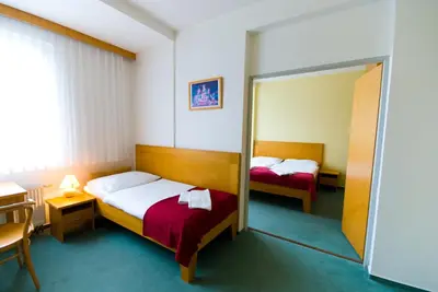 a hotel room with two beds and a mirror at Hotel Smaragd in Prague