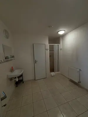 an empty bathroom with a toilet and a sink at Hotel Koruna in Roudnice nad Labem