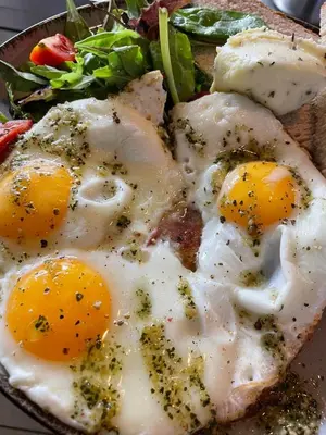 two fried eggs on a plate with a salad at Hotel Koruna in Roudnice nad Labem