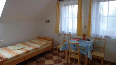 a bedroom with two beds and a table and chairs at Pension Camp Prager in Prague