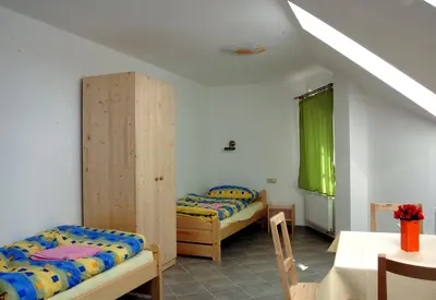 a bedroom with two beds and a table and a table sidx sidx sidx at Pension Camp Prager in Prague