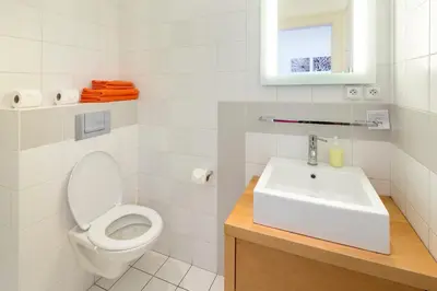 a white bathroom with a toilet and a sink at Dušní Apartments in Prague