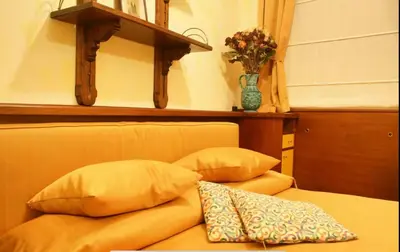 a bed with two pillows and a vase of flowers at Residence Týnská in Prague
