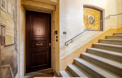 a hallway with a door and stairs in a building at Residence Týnská in Prague