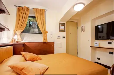 a small bedroom with a bed and a window at Residence Týnská in Prague