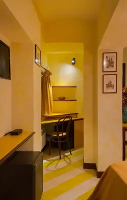 a room with yellow walls and a desk with a chair at Residence Týnská in Prague