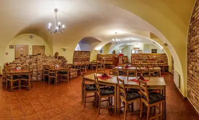 a restaurant with tables and chairs in a room at Hotel STARÝ PIVOVAR in Prague